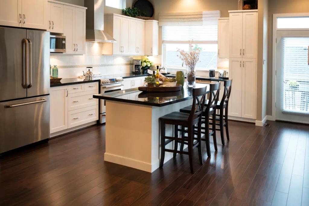 Classic white kitchen with black granite island and dark hardwood floors